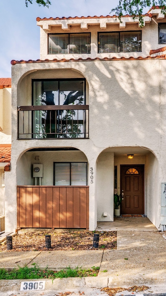 view of front of home featuring a balcony and stucco siding