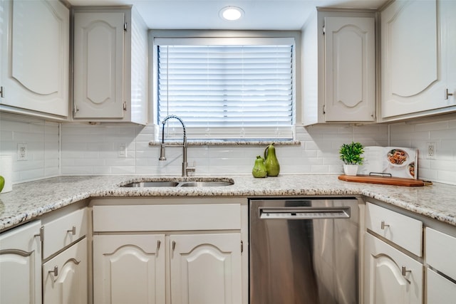 kitchen featuring stainless steel dishwasher, a sink, dishwasher, and tasteful backsplash