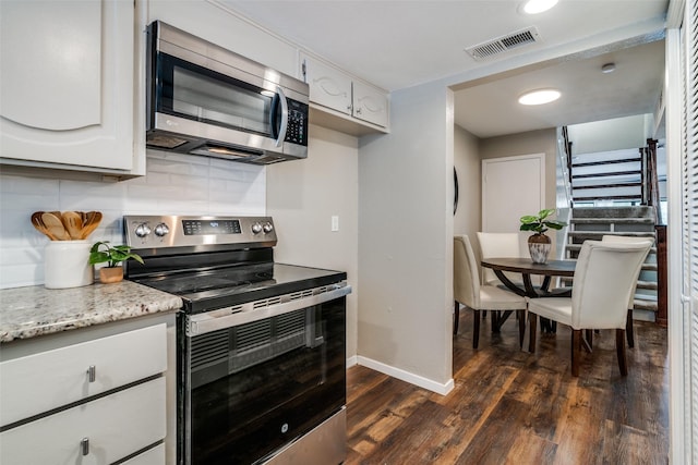 kitchen with visible vents, baseboards, dark wood finished floors, appliances with stainless steel finishes, and backsplash