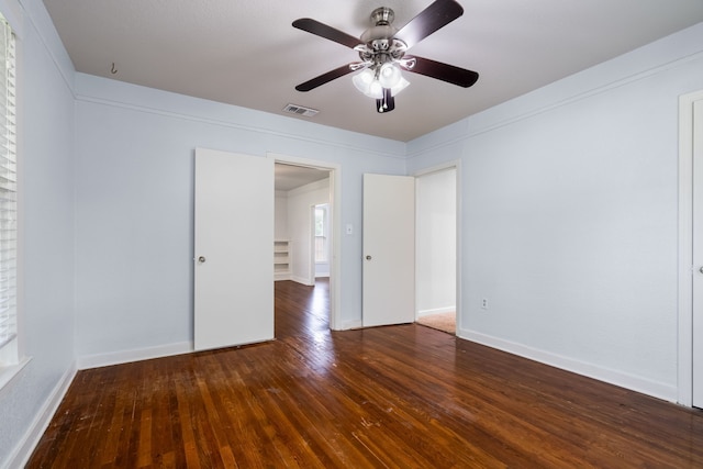 spare room featuring visible vents, ceiling fan, hardwood / wood-style flooring, and baseboards