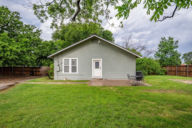 rear view of house featuring a yard, a fenced backyard, and a patio area