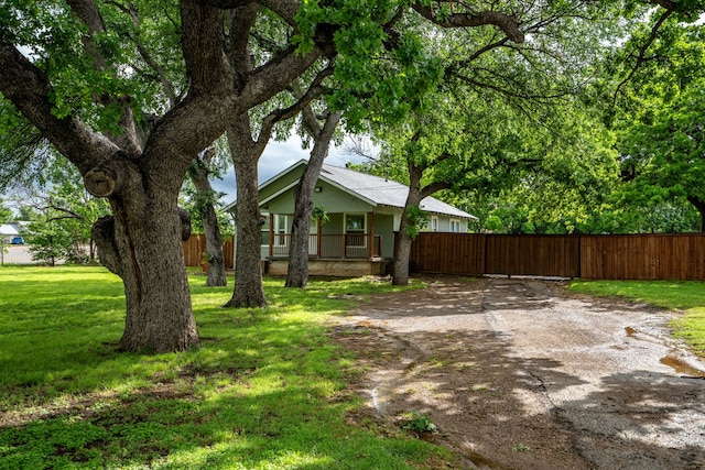 view of yard featuring covered porch and fence