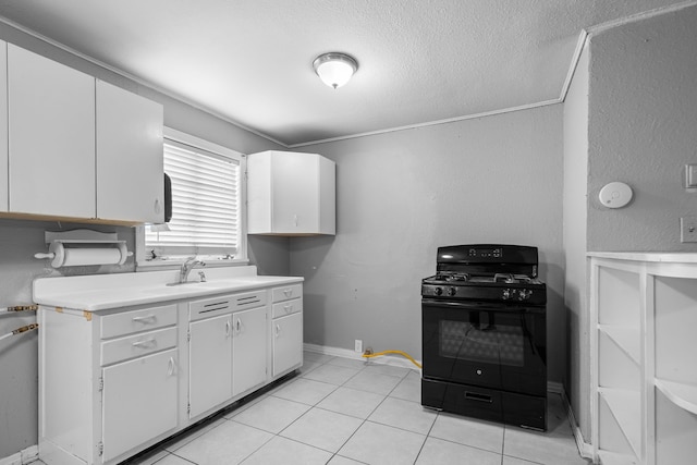 kitchen featuring light countertops, white cabinets, gas stove, and a sink
