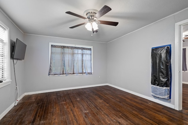 interior space featuring ornamental molding, a ceiling fan, wood finished floors, and baseboards