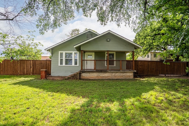 bungalow-style house featuring a front yard, covered porch, and fence