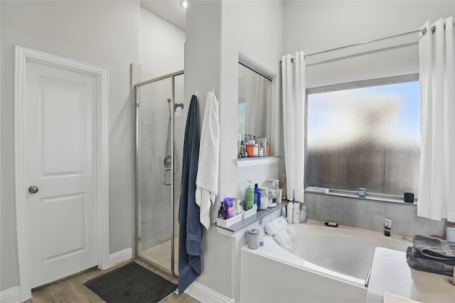 1164 Red Hawk Ln, Forney, TX 75126 - bathroom with a stall shower, a bath, wood finished floors, and baseboards