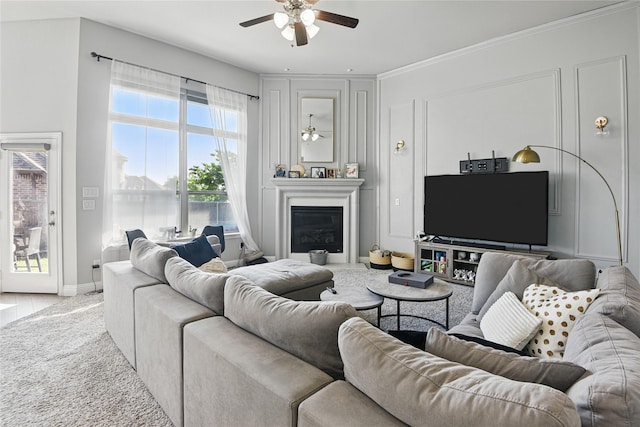 1164 Red Hawk Ln, Forney, TX 75126 - living room featuring light carpet, a glass covered fireplace, baseboards, a ceiling fan, and crown molding