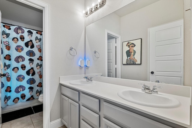 full bath with double vanity, toilet, tile patterned flooring, and a sink