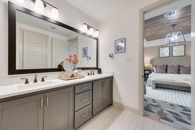 bathroom featuring visible vents, connected bathroom, double vanity, and a sink