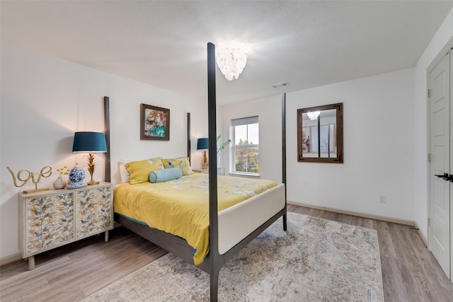 bedroom with visible vents, baseboards, and light wood-style floors