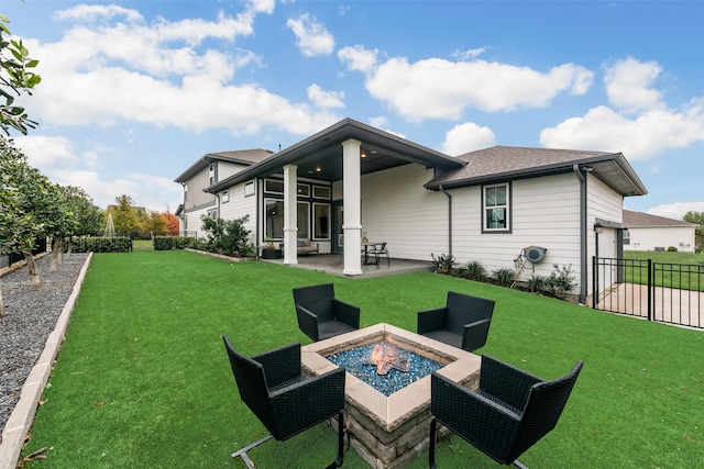 rear view of property with a patio, a yard, a fenced backyard, and an outdoor fire pit