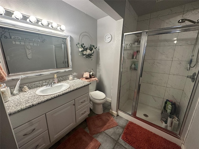 bathroom featuring toilet, a stall shower, and vanity