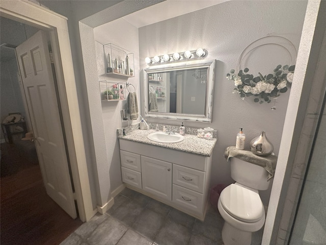 bathroom with toilet, tile patterned flooring, and vanity