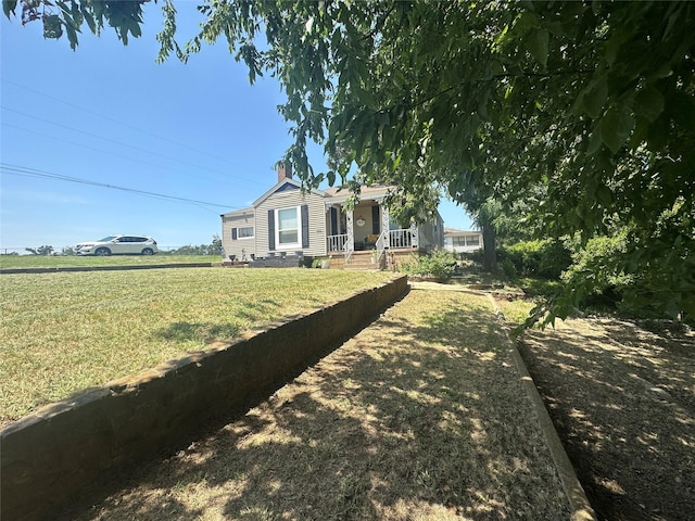 view of front facade with a chimney and a front yard