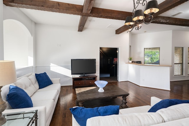 home office with dark wood-style flooring, a high ceiling, built in desk, a wainscoted wall, and a notable chandelier