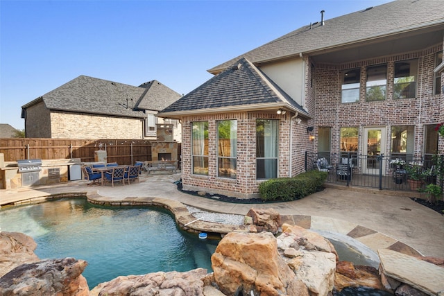 1374 Deer Lake Dr, Frisco, TX 75036 - view of pool with an outdoor kitchen, fence, a patio, area for grilling, and a stone fireplace