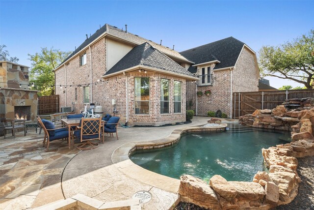 1374 Deer Lake Dr, Frisco, TX 75036 - view of swimming pool with an outdoor stone fireplace, a patio, and a fenced backyard