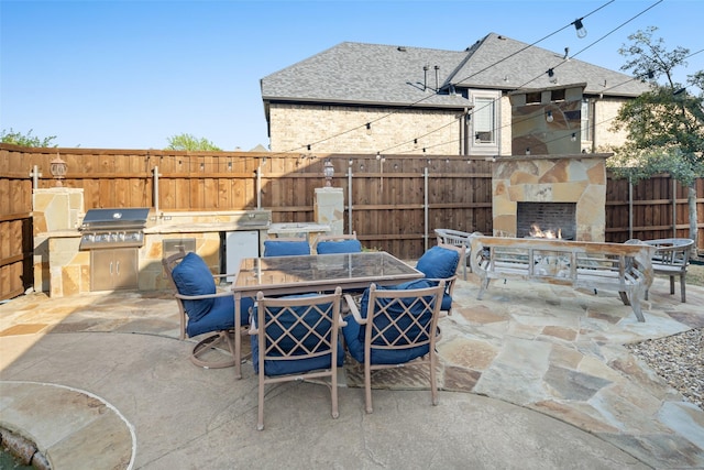 1374 Deer Lake Dr, Frisco, TX 75036 - view of patio / terrace featuring an outdoor stone fireplace, outdoor dining area, a fenced backyard, an outdoor kitchen, and grilling area