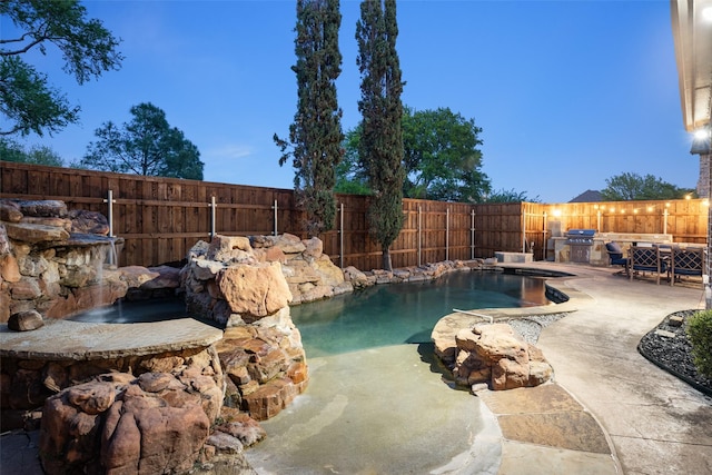 view of swimming pool with a stone fireplace, fence, a patio, and outdoor dining area