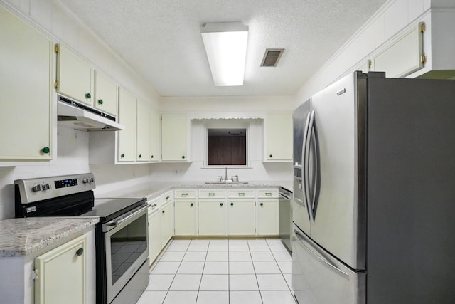 2134 Braune Rd, Abilene, TX 79606 - kitchen with appliances with stainless steel finishes, under cabinet range hood, light countertops, a textured ceiling, and light tile patterned floors