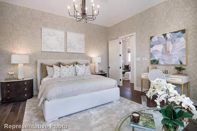 bedroom featuring an inviting chandelier, wood finished floors, and wallpapered walls