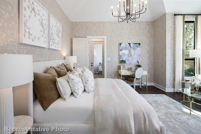 bedroom with an inviting chandelier, wallpapered walls, dark wood-style flooring, and baseboards