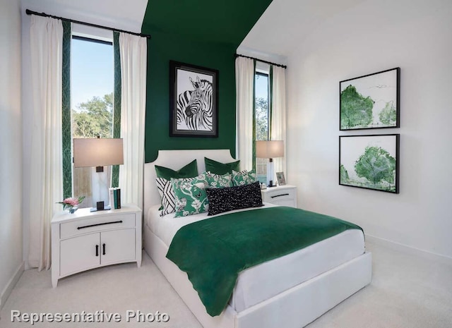 bedroom featuring light colored carpet and baseboards
