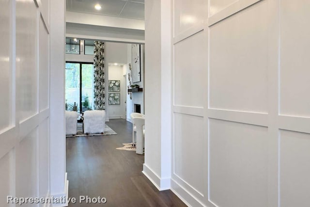 hallway featuring dark wood finished floors and baseboards