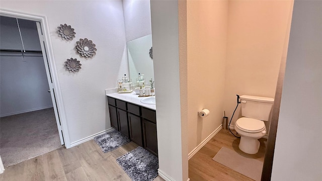 13124 N Haven Way, Providence Village, TX 76227 - bathroom featuring wood finished floors, vanity, toilet, baseboards, and a walk in closet