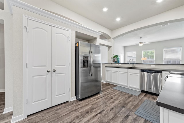 kitchen with dark countertops, appliances with stainless steel finishes, dark wood-style floors, and a sink