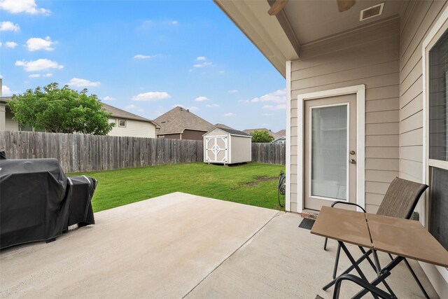 view of patio / terrace with an outdoor structure, a fenced backyard, visible vents, and a shed