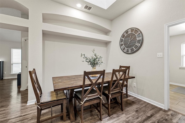 dining space with visible vents, dark wood-style flooring, baseboards, and a healthy amount of sunlight