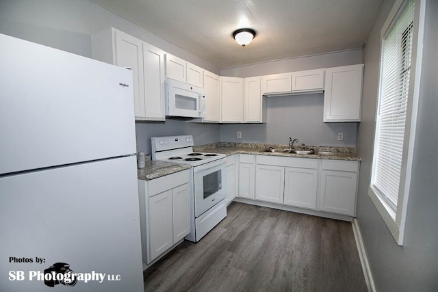 kitchen with wood finished floors, white appliances, white cabinetry, and a sink