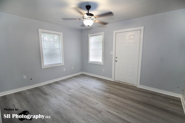 unfurnished room featuring baseboards, ceiling fan, and dark wood-style flooring