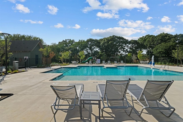 pool with fence and a patio area