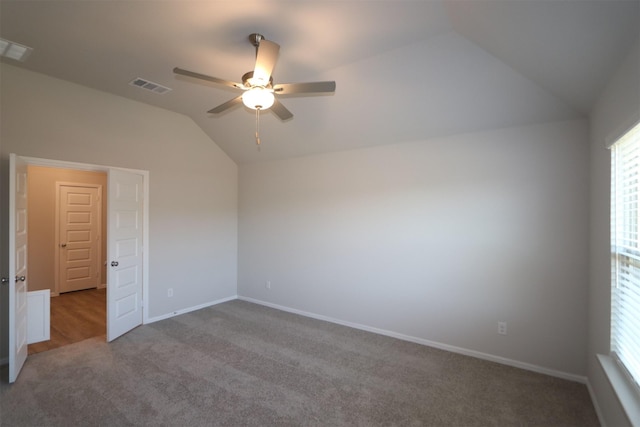 empty room with carpet floors, baseboards, visible vents, a ceiling fan, and lofted ceiling