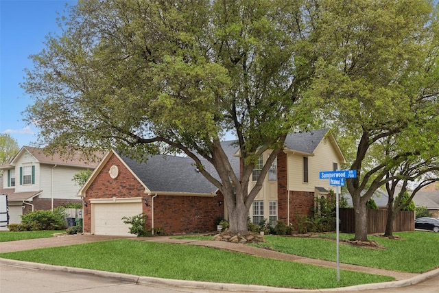 traditional-style home featuring brick siding, fence, a front lawn, concrete driveway, and an attached garage