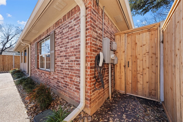 view of home's exterior featuring fence and brick siding