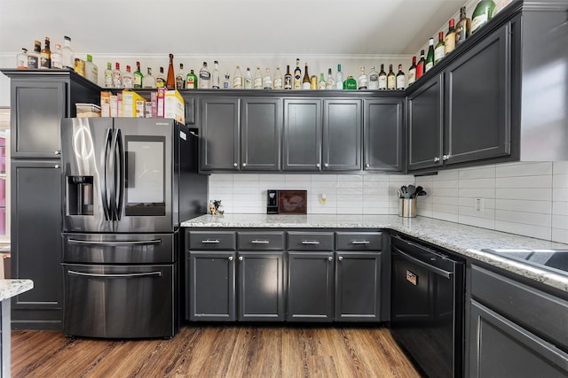 kitchen with tasteful backsplash, light stone counters, stainless steel fridge, dark wood-style flooring, and dishwasher
