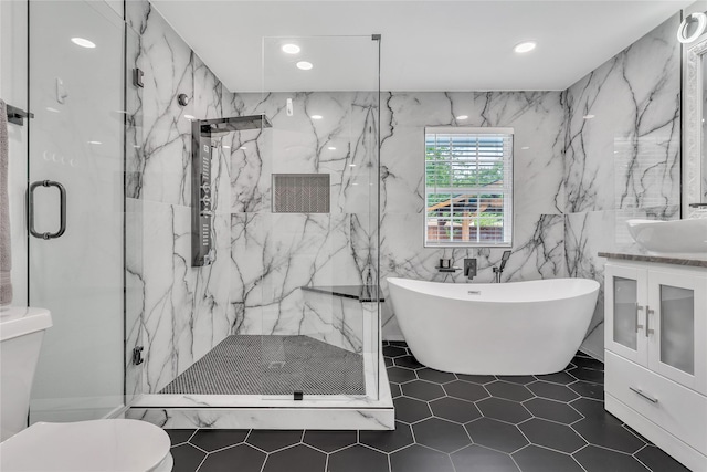 full bath featuring vanity, tile patterned floors, toilet, a marble finish shower, and a soaking tub