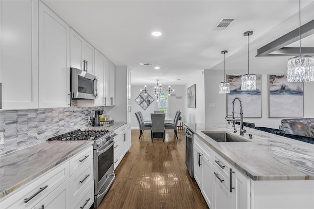 kitchen featuring a sink, dark wood-style flooring, stainless steel appliances, a notable chandelier, and visible vents