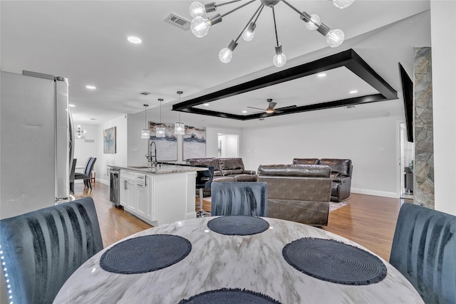 dining room with visible vents, recessed lighting, ceiling fan with notable chandelier, and light wood-style floors