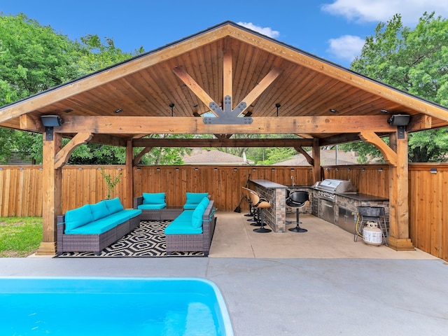 view of swimming pool with an outdoor kitchen, a gazebo, fence, and grilling area