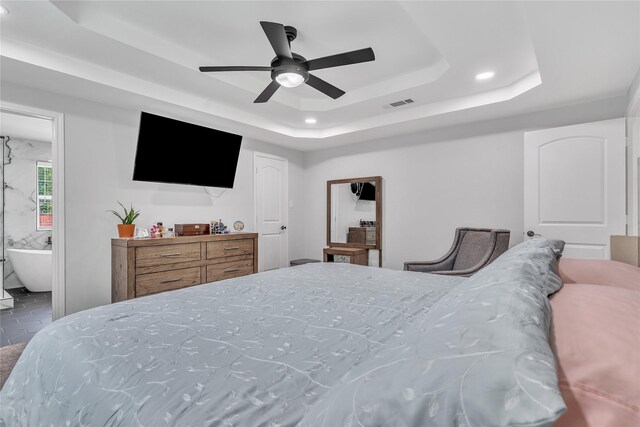 tiled bedroom featuring recessed lighting, connected bathroom, ceiling fan, a tray ceiling, and visible vents