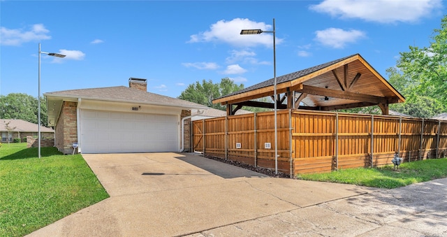 view of home's exterior with fence, a chimney, a yard, and a garage