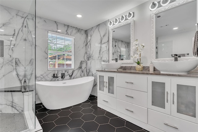 full bath with a marble finish shower, a sink, a freestanding bath, and visible vents