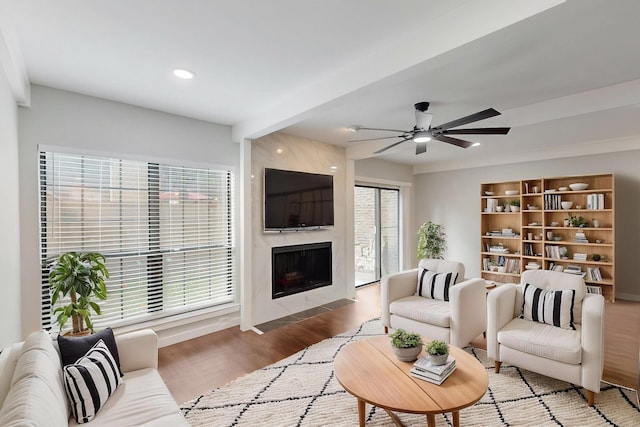 living room with ceiling fan, baseboards, recessed lighting, a fireplace, and wood finished floors