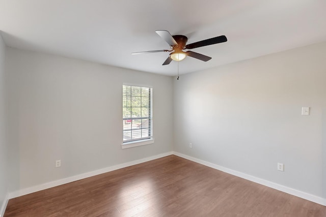 unfurnished room featuring baseboards, wood finished floors, and ceiling fan