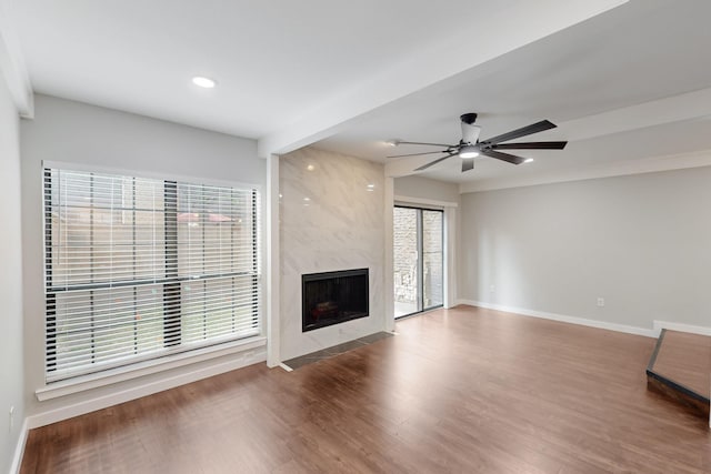 unfurnished living room with recessed lighting, wood finished floors, ceiling fan, a fireplace, and baseboards