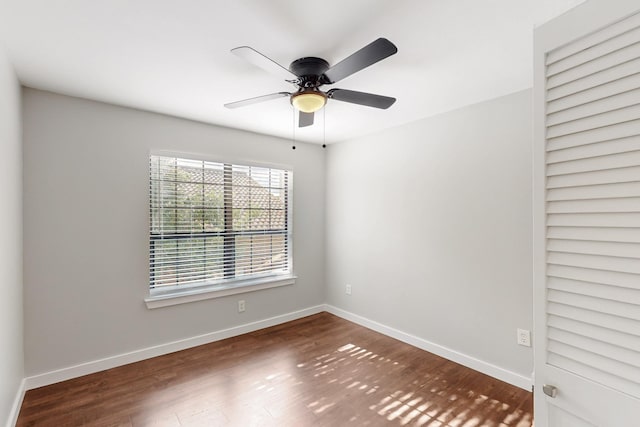 unfurnished room featuring baseboards, wood finished floors, and ceiling fan